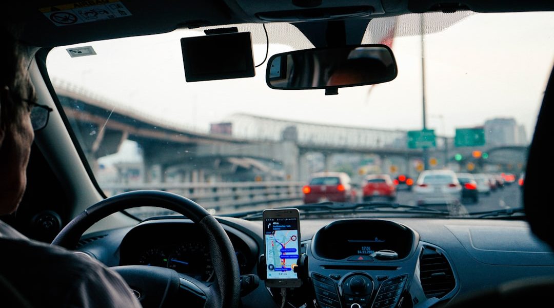 Smartphone navigation app mounted on a car dashboard in Georgia traffic, illustrating usage-based telematics auto insurance